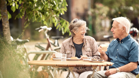 Älteres Paar sitzt am Tisch und macht Pause