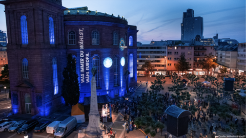 Bild zeigt die beleuchtete Paulskirche in Frankfurt am Main mit dem Spruch "Was immer du wählst, wähl Europa"