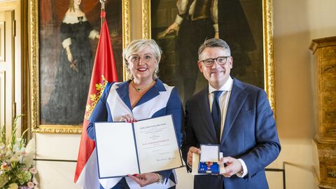 Ministerpräsident Boris Rhein überreicht Bettina Schmitt das Verdienstkreuz am Bande.