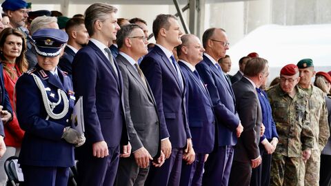 Ministerpräsident Rhein, Bundeskanzler Merz, Verteidiungsminister Pistorius und weitere Personen stehen zusammen.