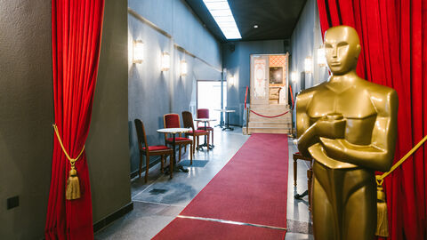 Eingang der FilmBühne in Bad Nauheim, man sieht einen Gang mit rotem Teppich, lebensgroßer Oscar-Statue und roten Vorhängen